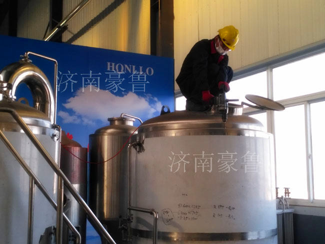 工人在加工啤酒設備罐體 工人在加工啤酒設備罐體